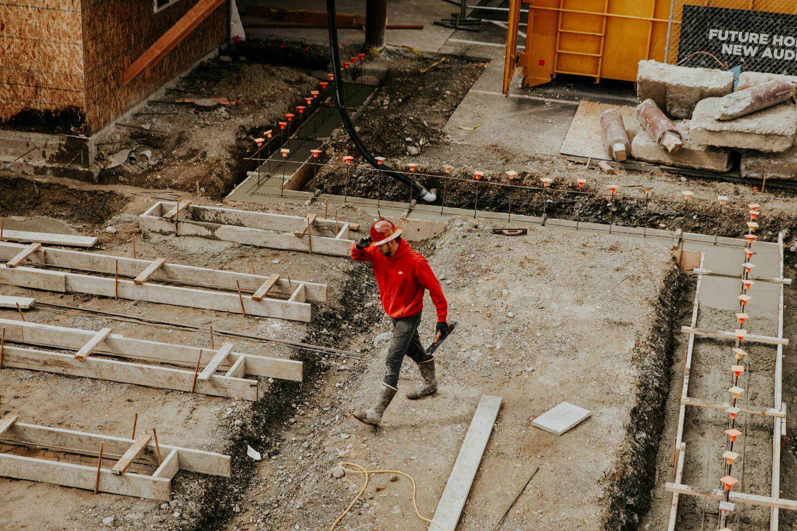 Construction worker pouring fresh concrete from a cement mixer into a mold at an industrial facility